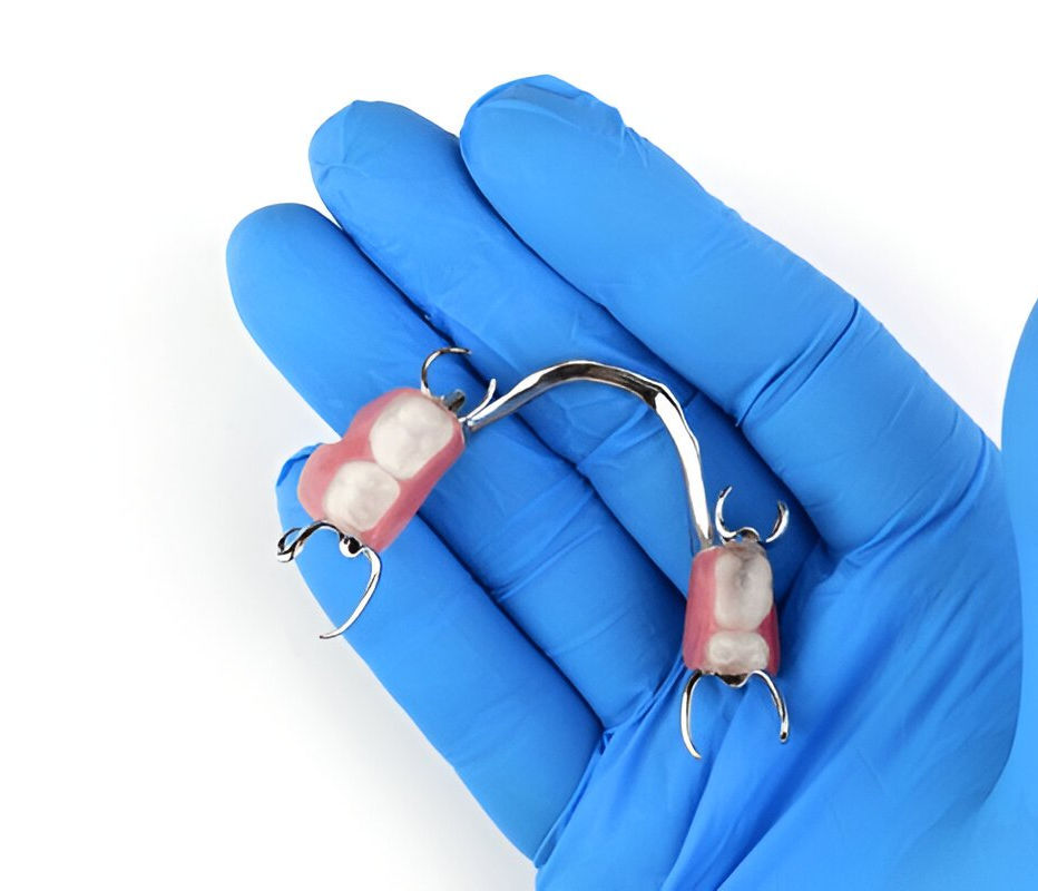 Smiling man holding a lower full denture close to his mouth