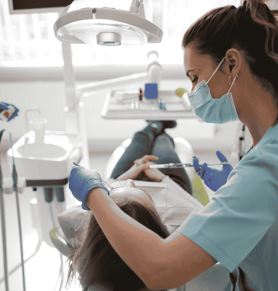 Dental professional applying fluoride treatment to a patient in a clinic