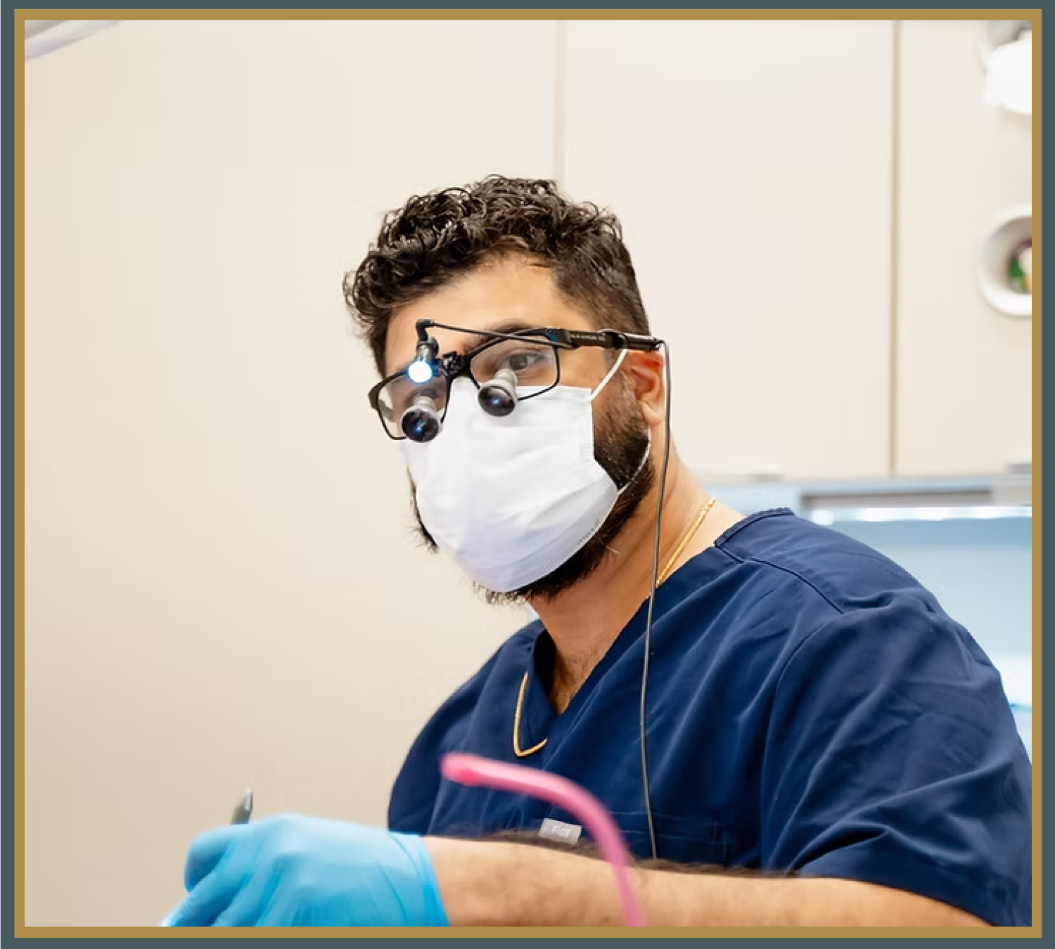 Male dentist wearing magnifying loupes and mask preparing for a dental procedure