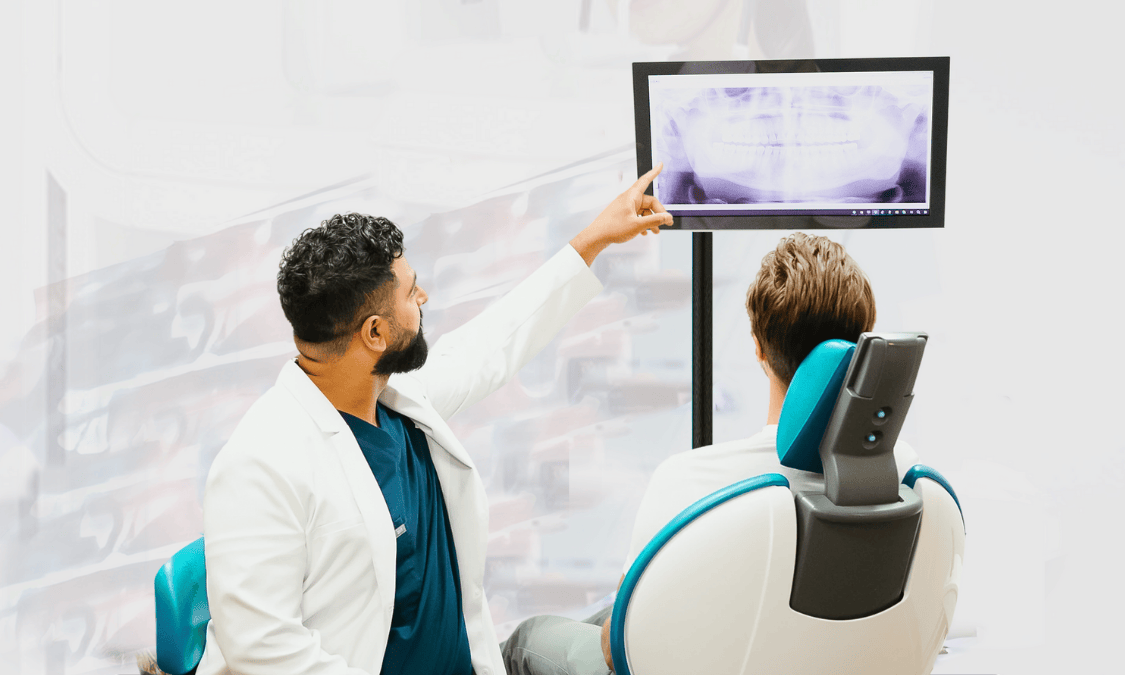 Dentist showing a patient their dental X-ray on a screen